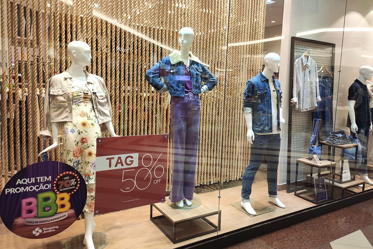 Imagem da vitrine da loja Damyler no Shopping Jardins com manequins vestindo peças em promoção