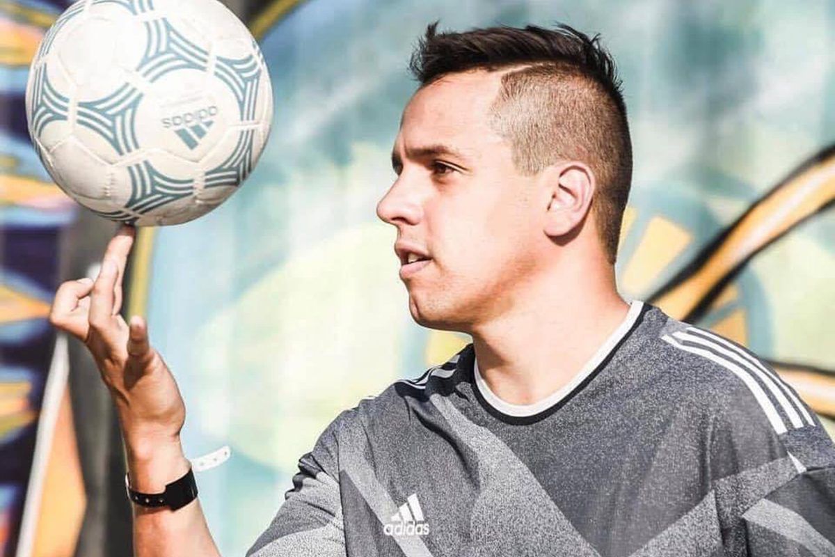 Foto do atleta Diego Freestyle rodando uma bola de futebol no dedo de uma das mãos