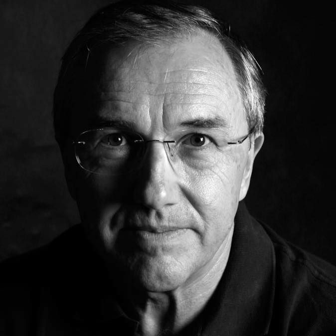 Imagem do rosto do jornalista e escritor Laurentino Gomes em preto e branco e com óculos