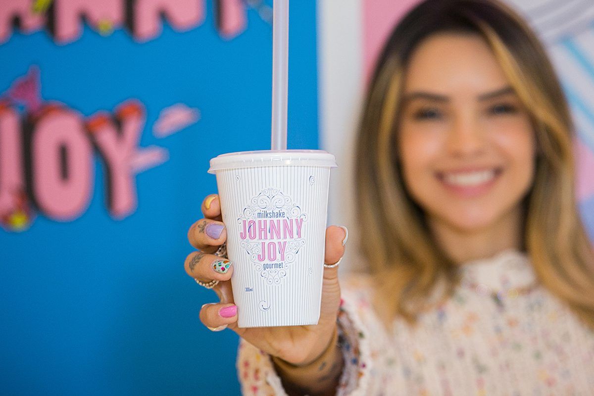 Imagem de mulher loira mostrando copo com milkshake da Johnny Joy, que acaba de inaugurar loja em Aracaju, no Shopping Jardins