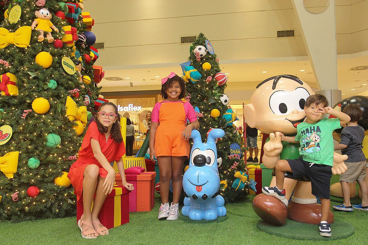 Imagem de três crianças posando na decoração temática Natal com a Turma da Mônica no Shopping Jardins