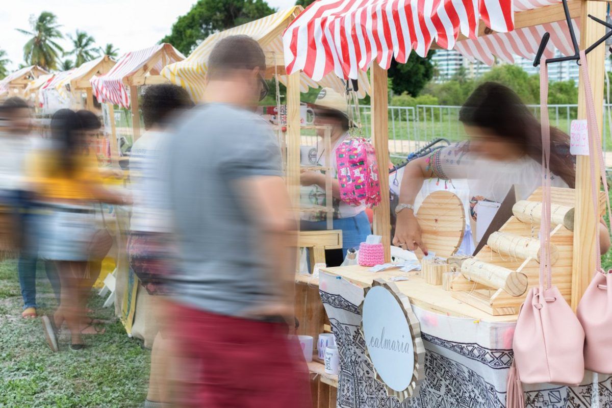Imagem da feirinha da gambiarra com pessoas circulando pelas barraquinhas